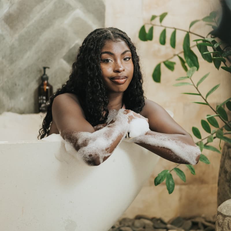 Guest enjoying relaxing warm bubble bath in deep stone soaking bathtub at Rimbun Canggu Villa
