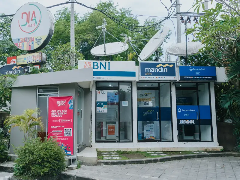 An outdoor ATM center in Canggu featuring BNI, Mandiri, and Permata Bank machines, located conveniently near the Dia Mart minimarket for easy cash withdrawals.