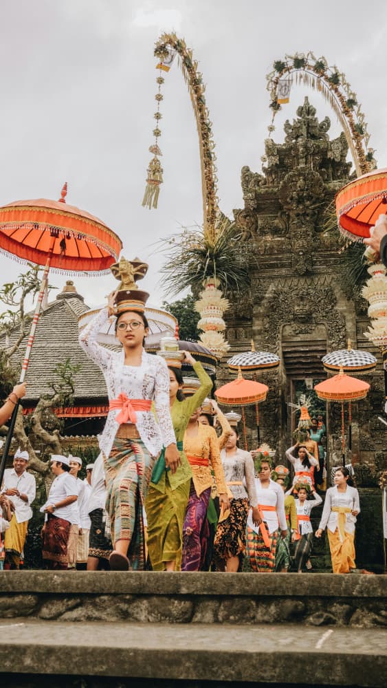 Balinese women in traditional kebaya carrying offerings during a Galungan procession in Penglipuran village.